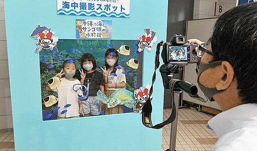 来場記念号外に笑顔　沖縄の海とサンゴ礁の水族館